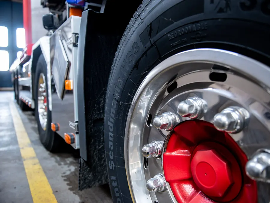 Kuorma-auton etupyörä ja punainen napa Truck Service Kuopion hallissa